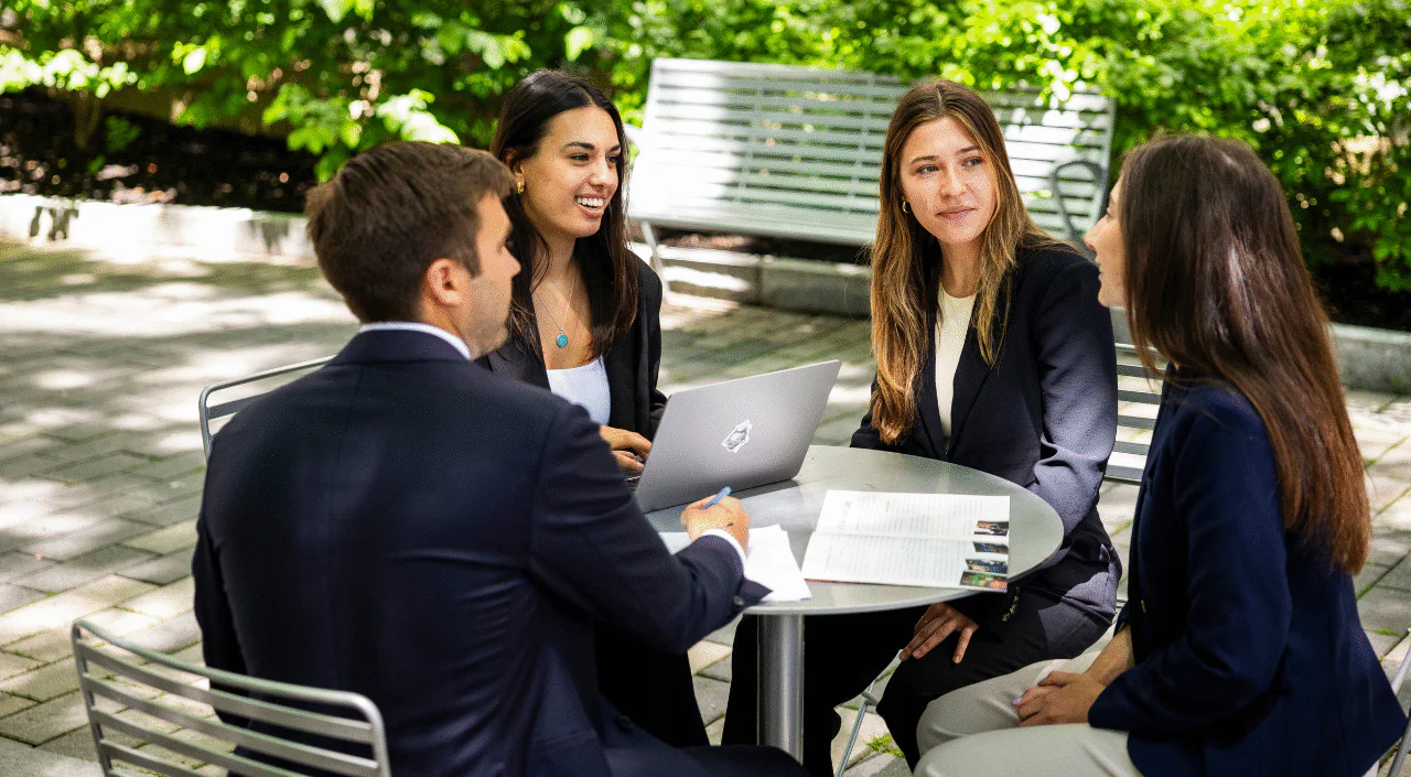 Students talking around a table outside