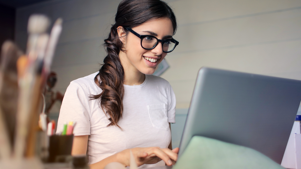 Brunette woman in glasses with laptop