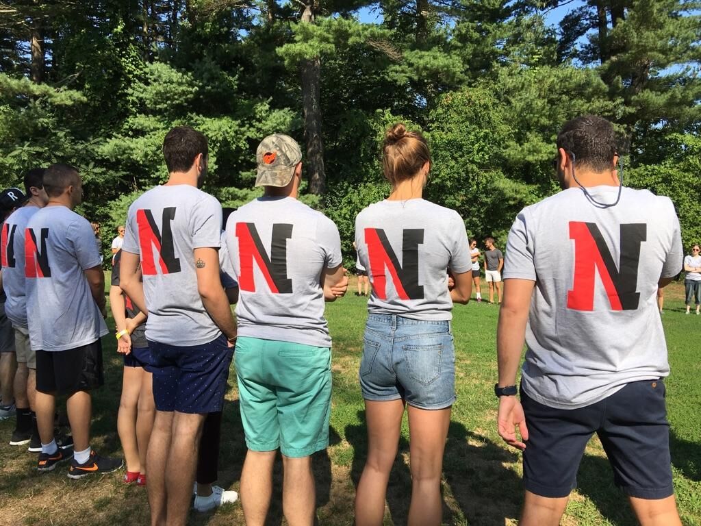 photo of the backs of northeastern students wearing northeastern shirts