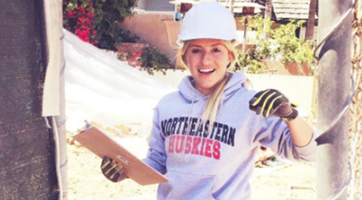 photo of a woman working on a construction sight with a northeastern sweatshirt