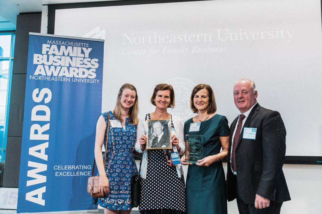 Photo of 3 woman and a man standing in front of the Family Business Awards sign