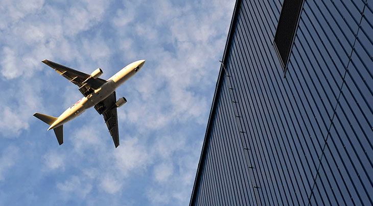 plane flying over building