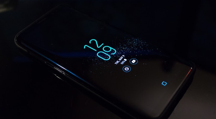 Photograph of a black Android phone that reads the time 12:09