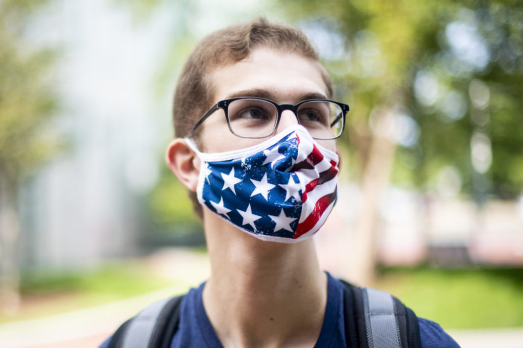 Photo of a student wearing glasses wearing a mask with the american flag on it