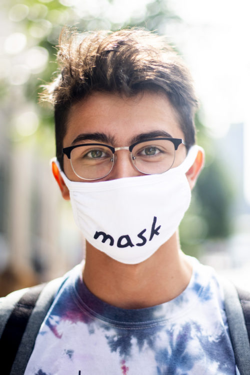 photo of a student with glasses and short brown hair wearing a face mask that says 'mask'