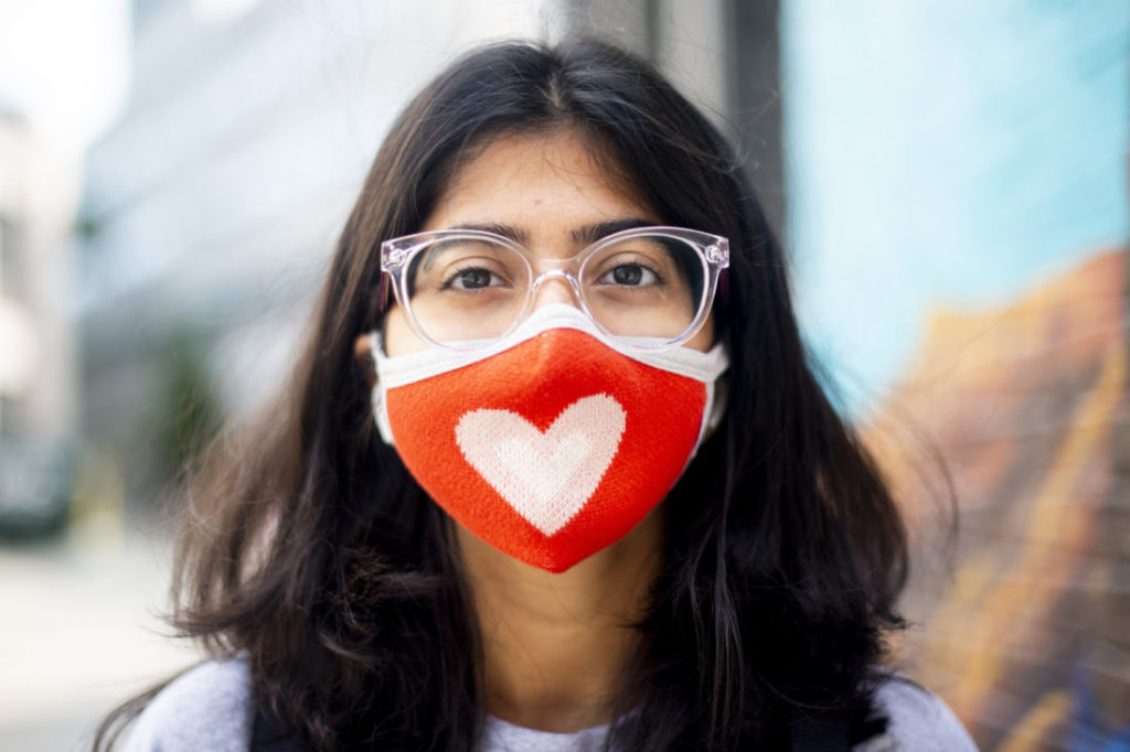 photo of a student with dark hair and glasses wearing a red mask with a white heart on it