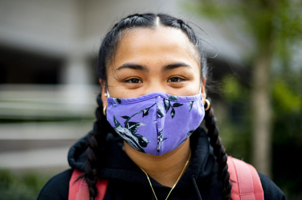 photo of a student with dark hair wearing a blue mask with flowers
