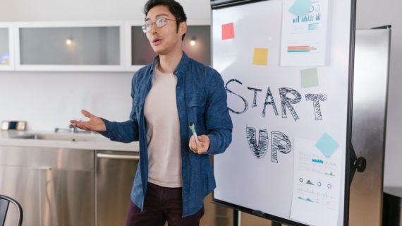 man in front of whiteboard that says start up