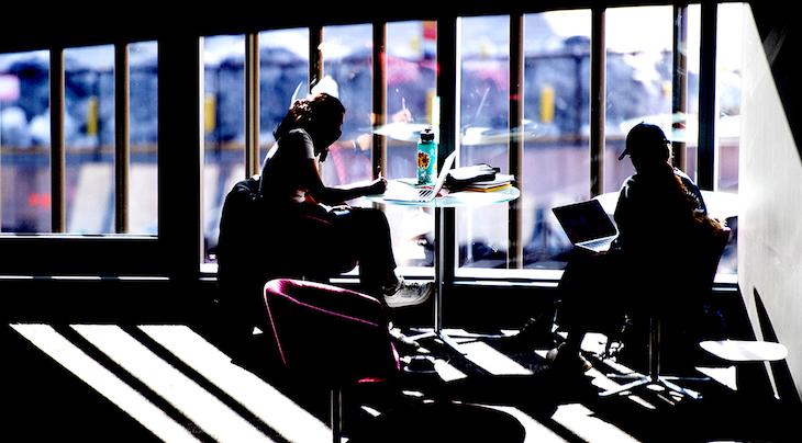 silhouette of two students studying