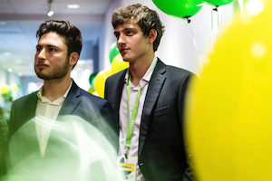 2 students surrounded by yellow and green balloons