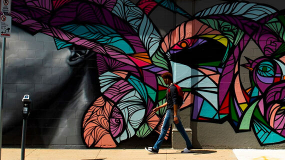 Student walks past mural