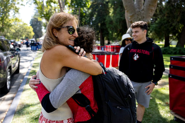 Student hugs person dropping them off at Oakland campus