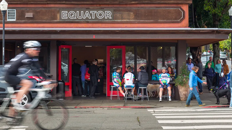 Biker rides past Equator coffee shop.