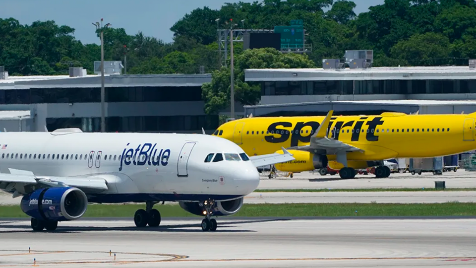 Spirit and JetBlue planes intersecting on a runway