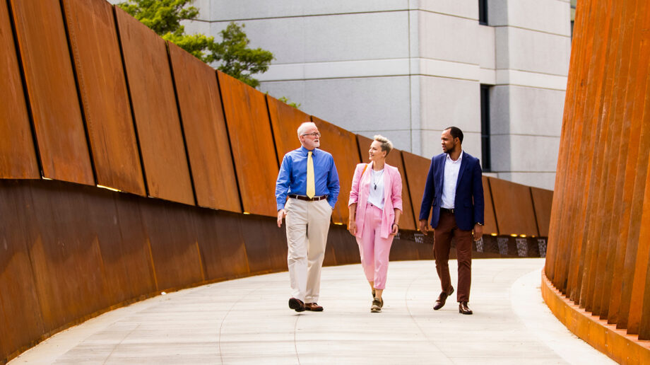 Three people walking Pedestrian Crossing bridge