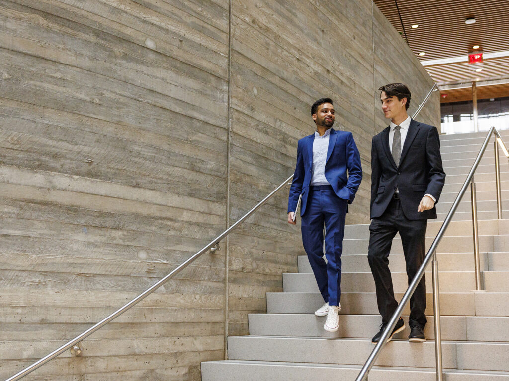 Two students walking down ISEC stairs