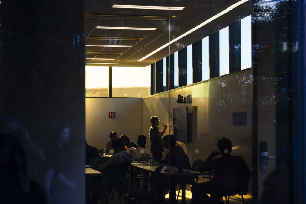 Professor in silhouette at white board