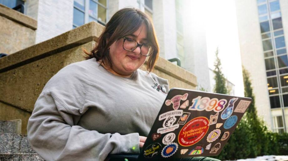 Student on laptop on Dodge Hall steps