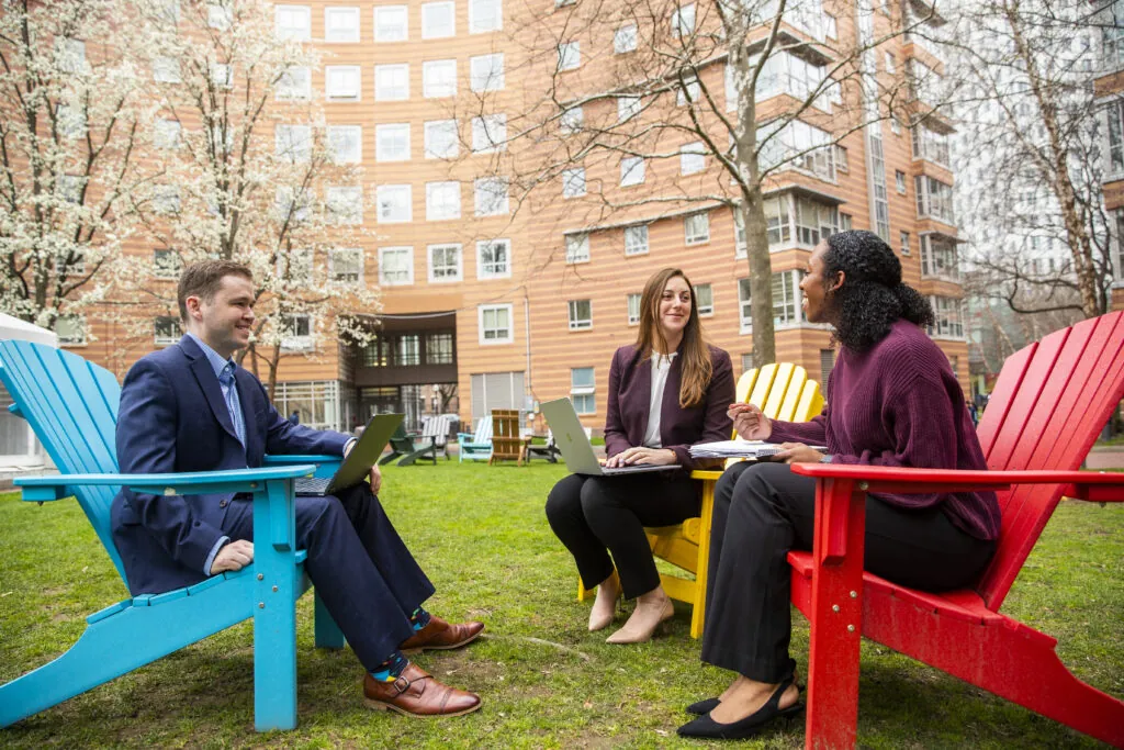 Three people on adirondack chairs