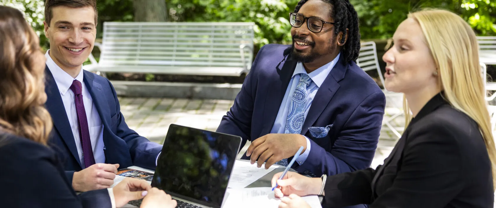 Four students sitting outside on Boston campus