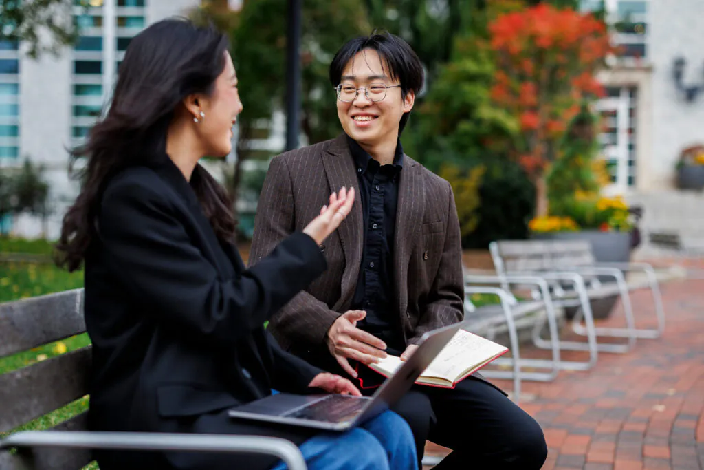 Students talking on a bench
