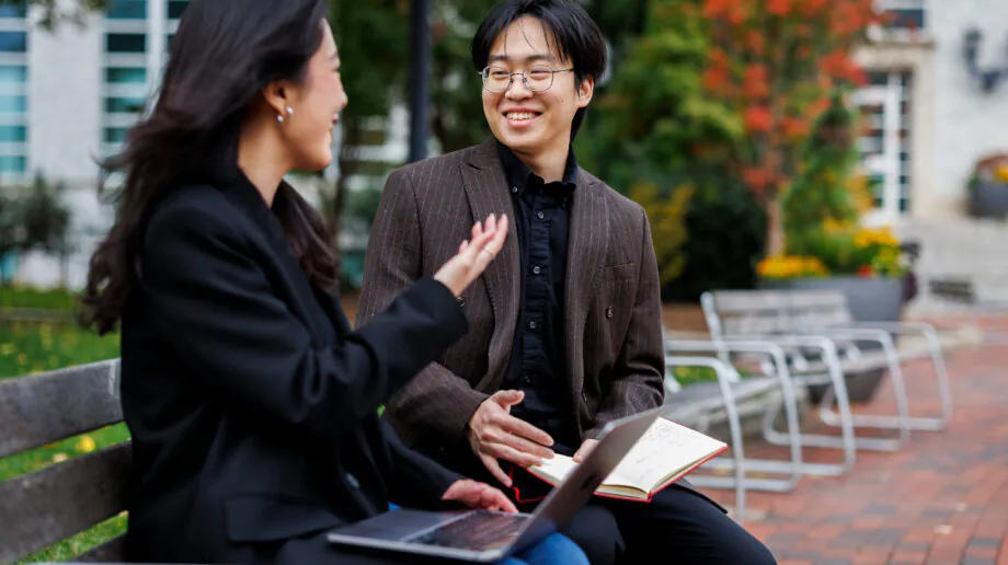 Students talking on a bench