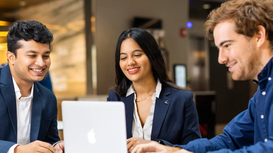 Three students looking at a laptop