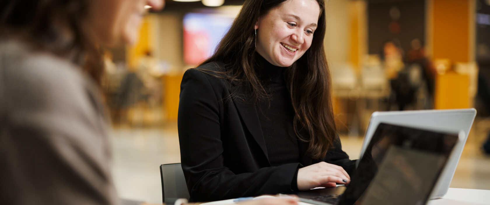 Two students looking at laptops